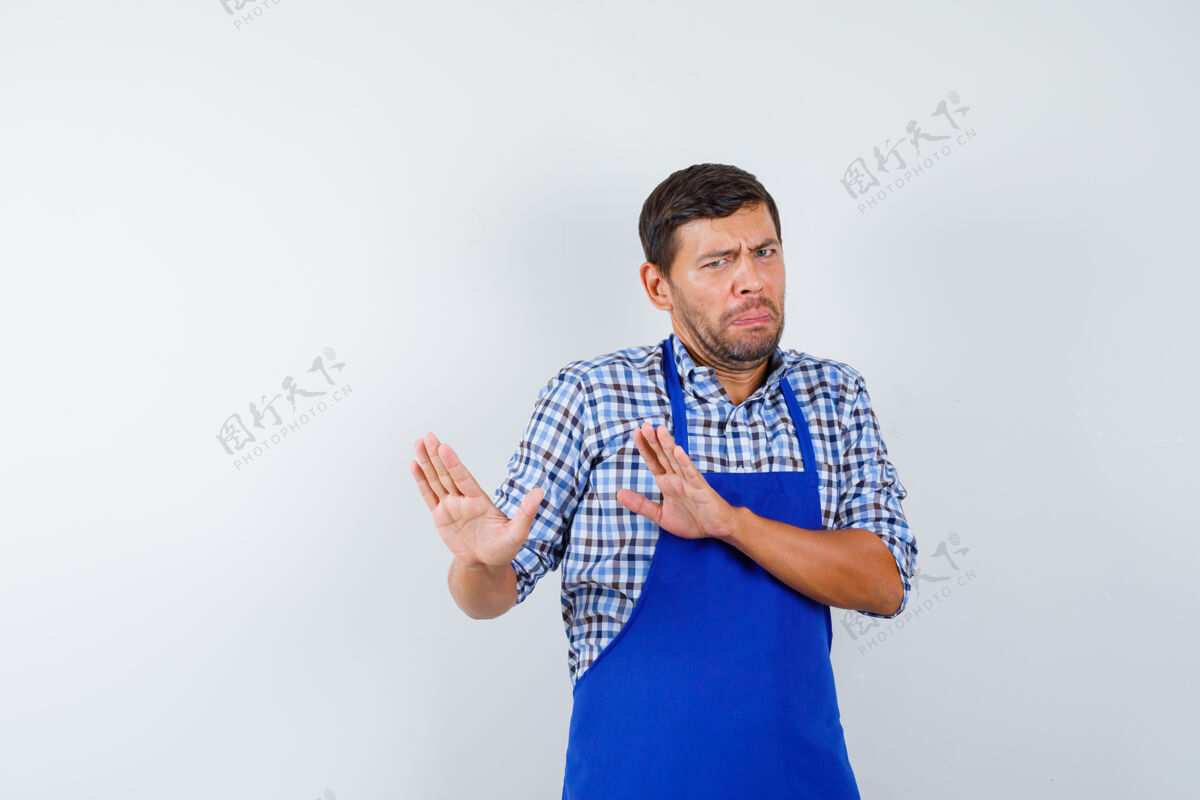年轻穿着蓝色围裙和衬衫的年轻男厨师男士围裙衬衫