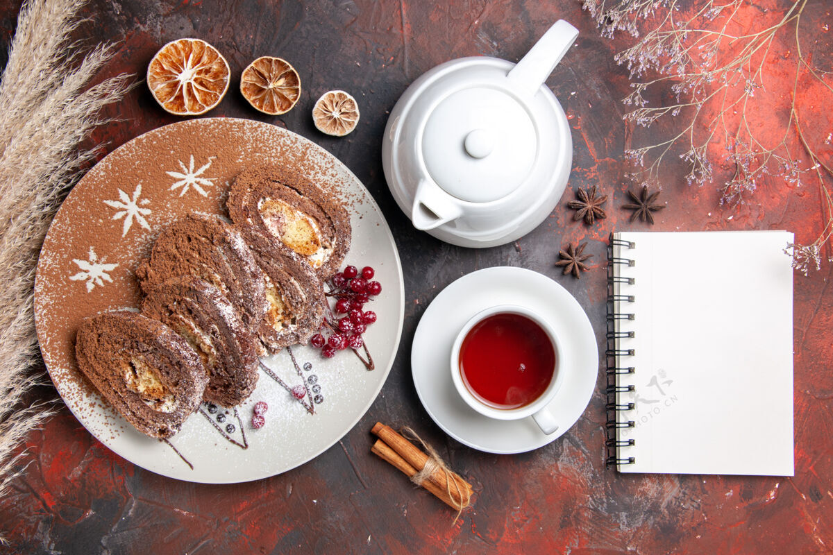 茶俯瞰美味饼干卷和一杯茶在黑暗的桌子上盘子食物蛋糕