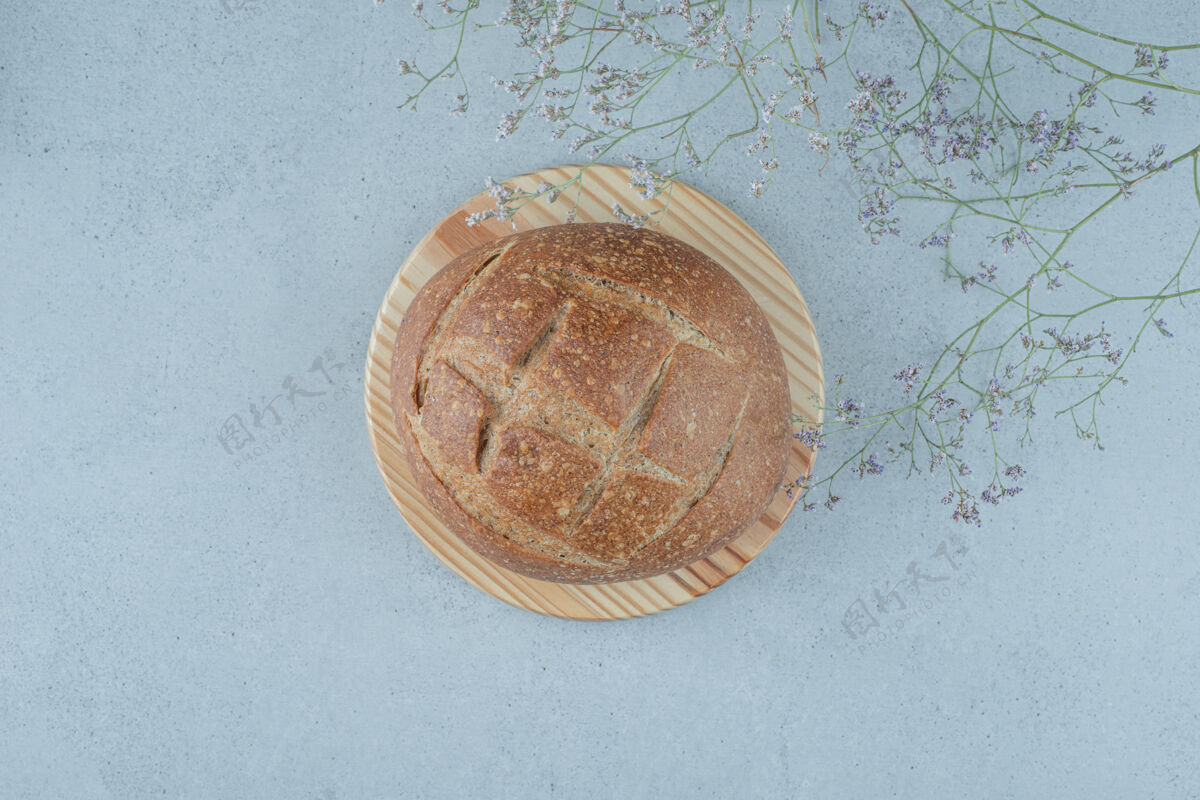 食品黑麦面包卷放在木板上 上面有植物顶视图棕色面包卷