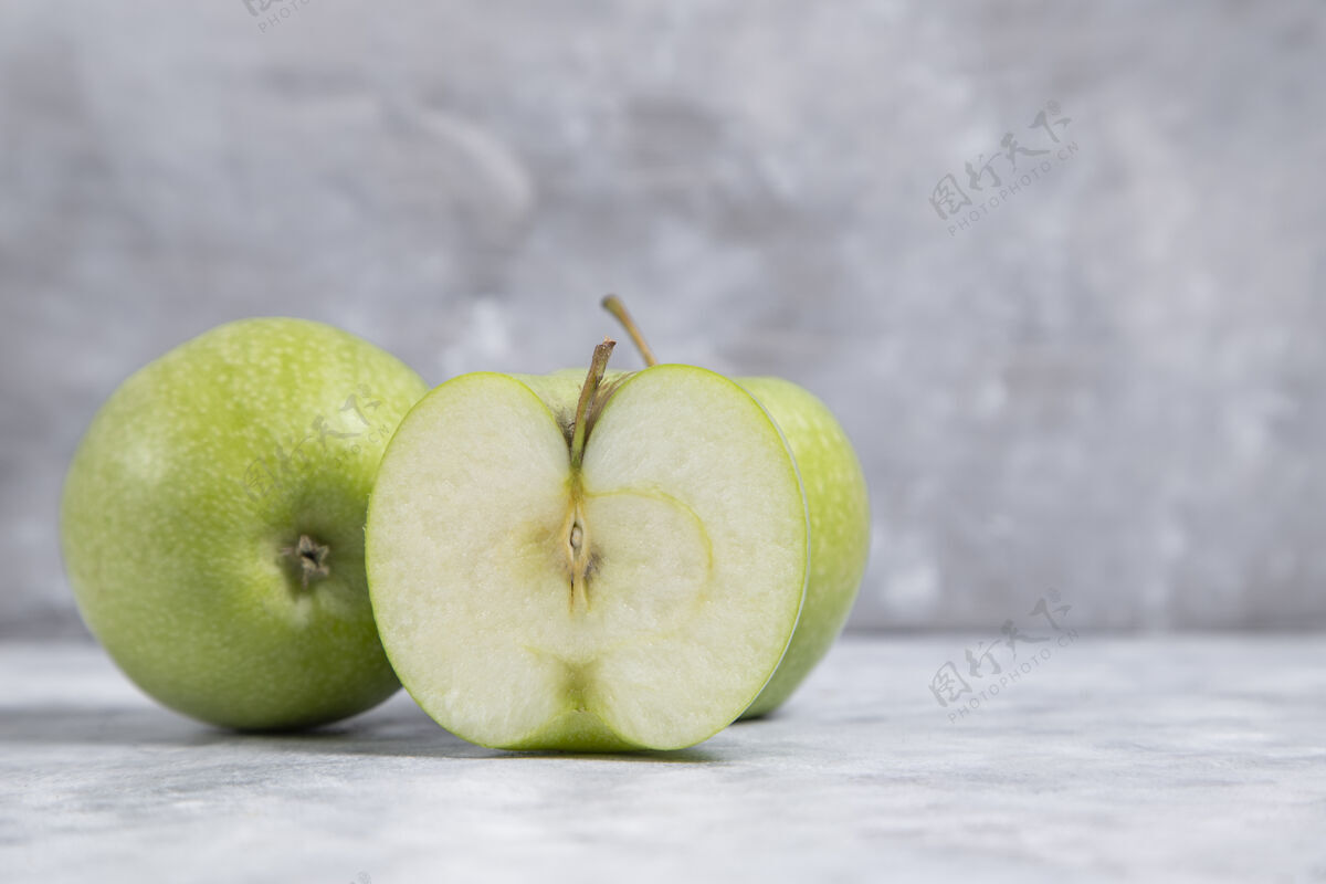 健康整个和切片新鲜成熟的青苹果水果放在大理石背景上高品质的照片切块味道纯净