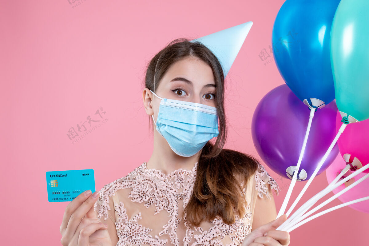 人特写前视图可爱的聚会女孩与医疗面具举行气球和卡气球可爱的聚会女孩举行