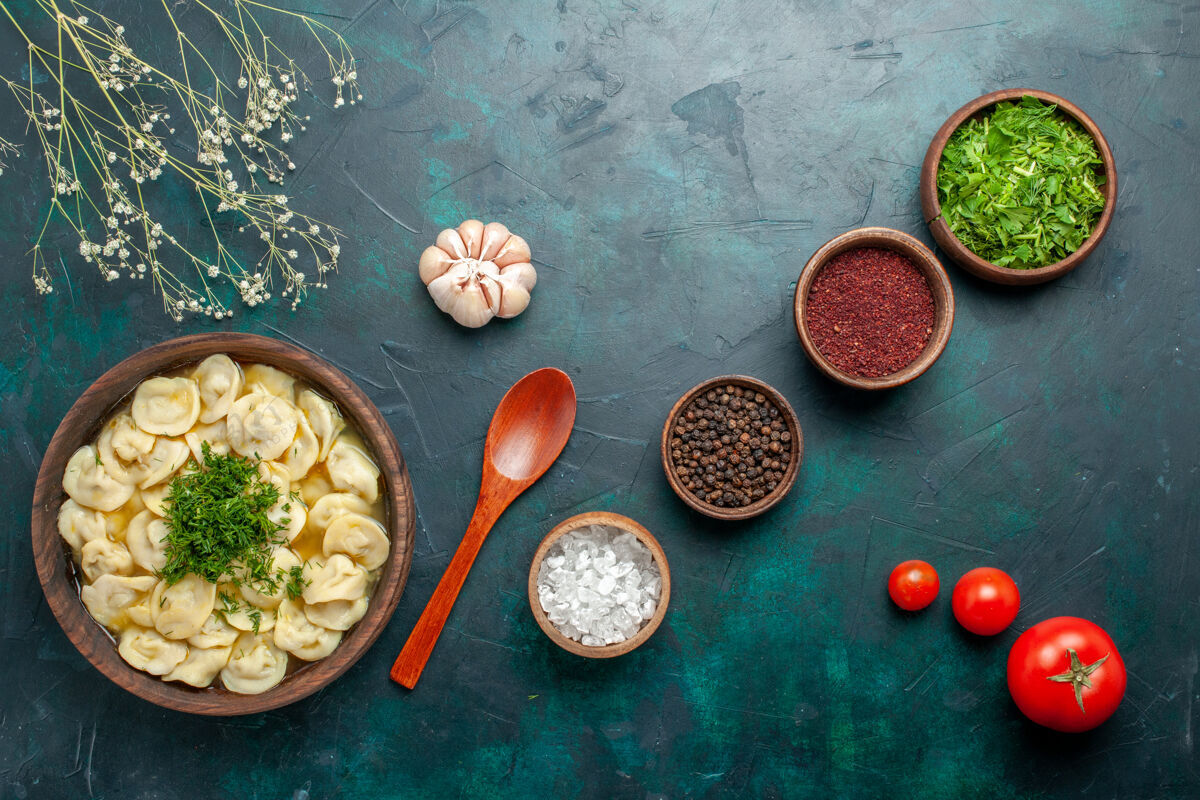 不同俯瞰美味的饺子汤 用不同的调味料放在深绿色的汤面上 汤食肉素面团面团容器汤