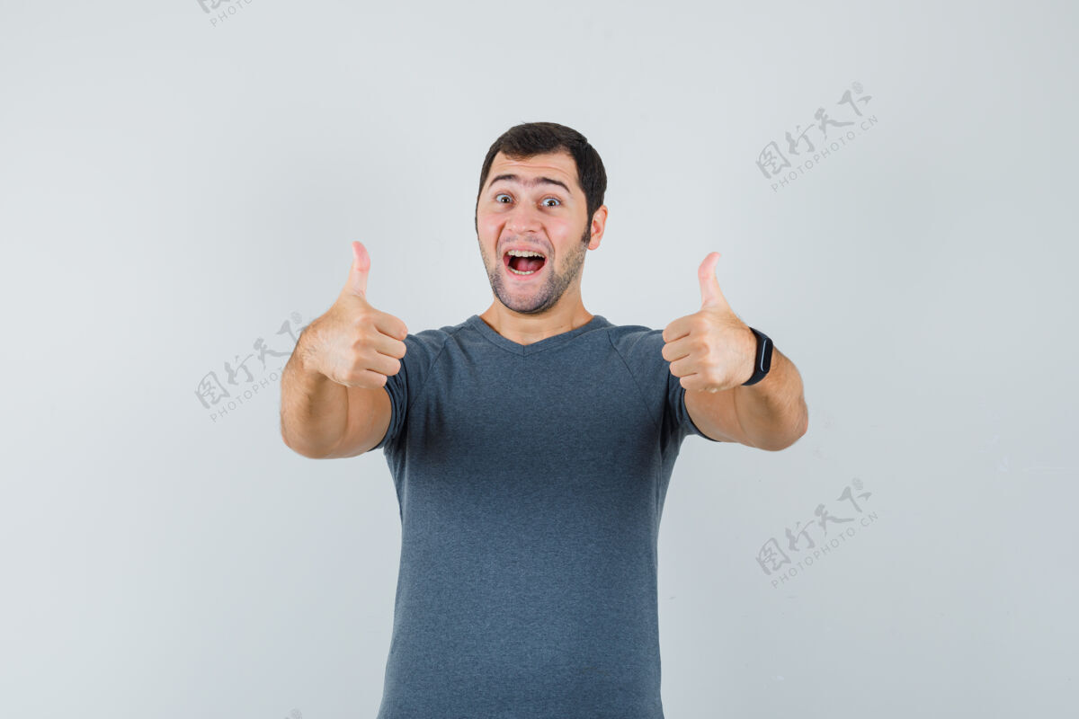 T恤身着灰色t恤的年轻男性 向上竖起大拇指 看上去很欢快手男孩商务网络摄像头