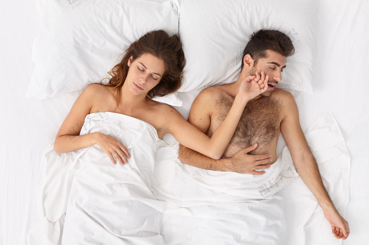 夜晚人 休息和睡眠的概念放松的家庭夫妇睡在舒适的床上 看到愉快的梦 女人伸出手对丈夫 有懒惰的一天 不想醒得很早男人舒适睡觉