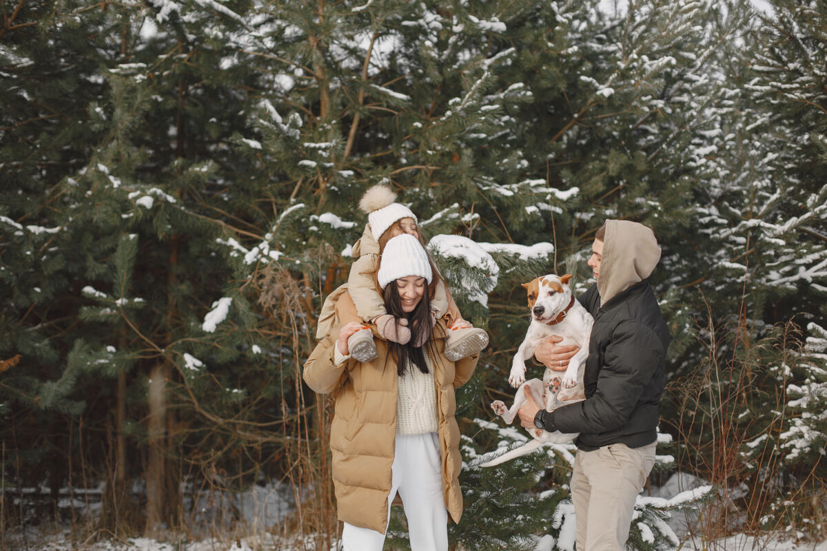 女孩一家人在度假时戴着编织的冬帽三帽子温暖