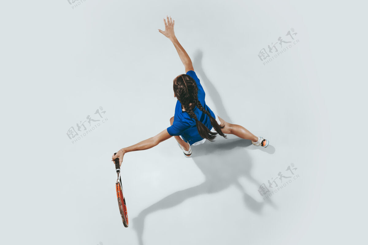 活跃穿蓝衬衫打网球的年轻女子她用球拍击球运动球顶视图