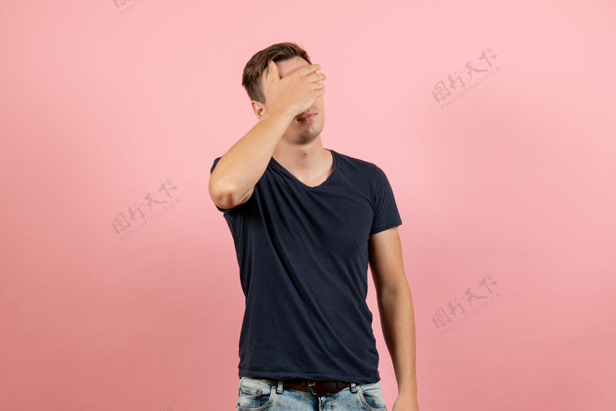 成人正面图：穿着深蓝色衬衫的年轻男性 在粉色背景上蒙着眼睛 男性模特 颜色 情感 男人情感人眼睛