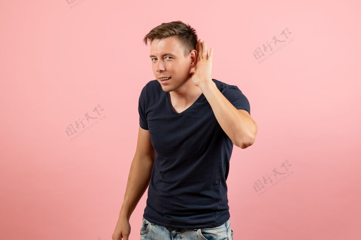 休闲正面图身着蓝色t恤的年轻男性在粉色背景上仔细聆听男性情感色彩模型人类青少年封闭情感