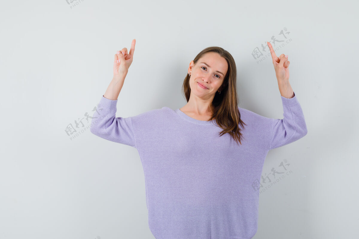美容年轻的女性指着紫丁香衬衫 看起来很高兴魅力皮肤头发