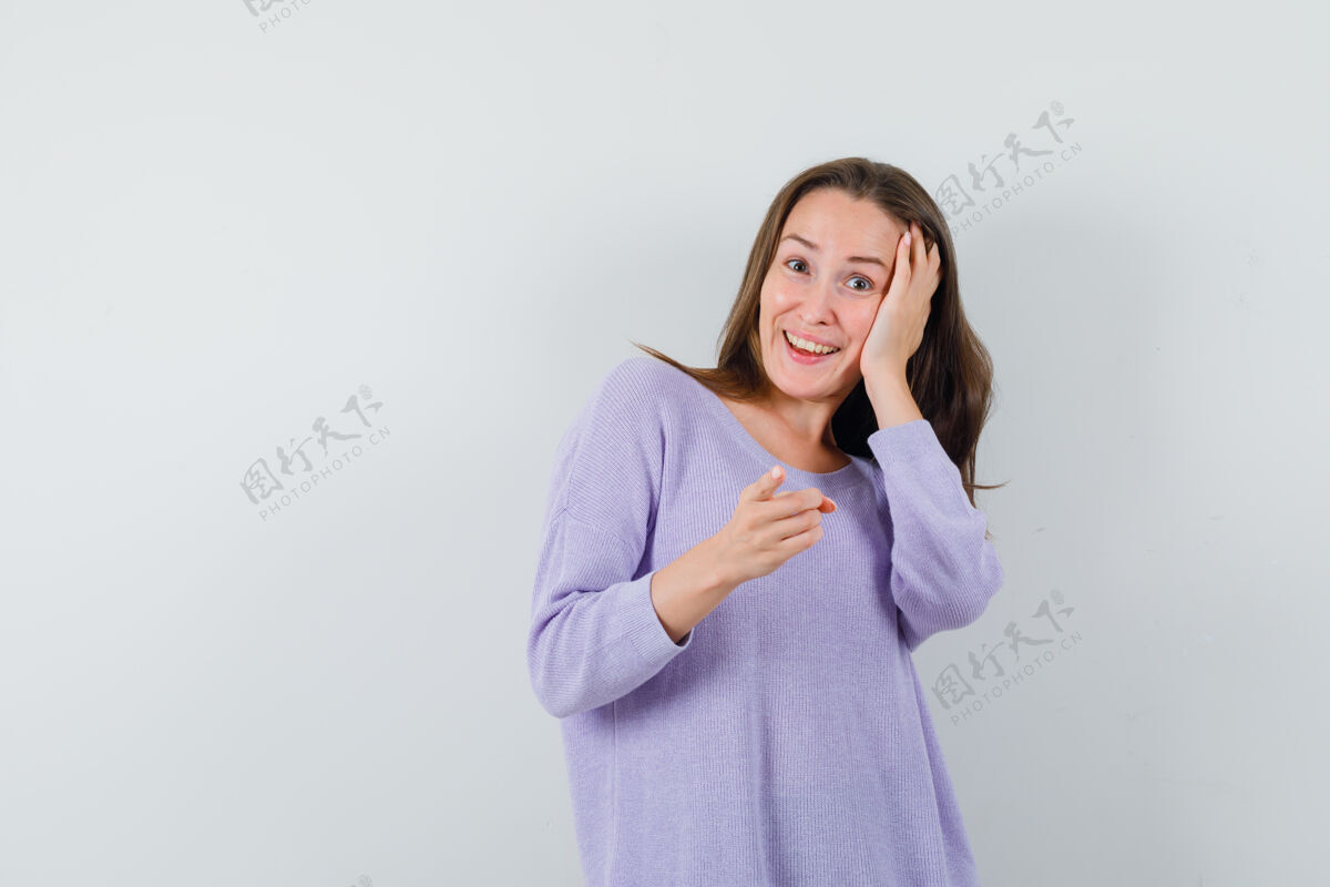 指向一位身穿淡紫色上衣的年轻女性 手放在头上 快活地指着前方看化妆头发姿势