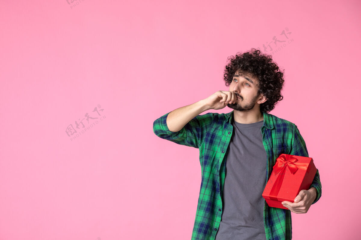 肖像浅粉色墙上红色包裹的年轻男性正面图礼盒日期文案