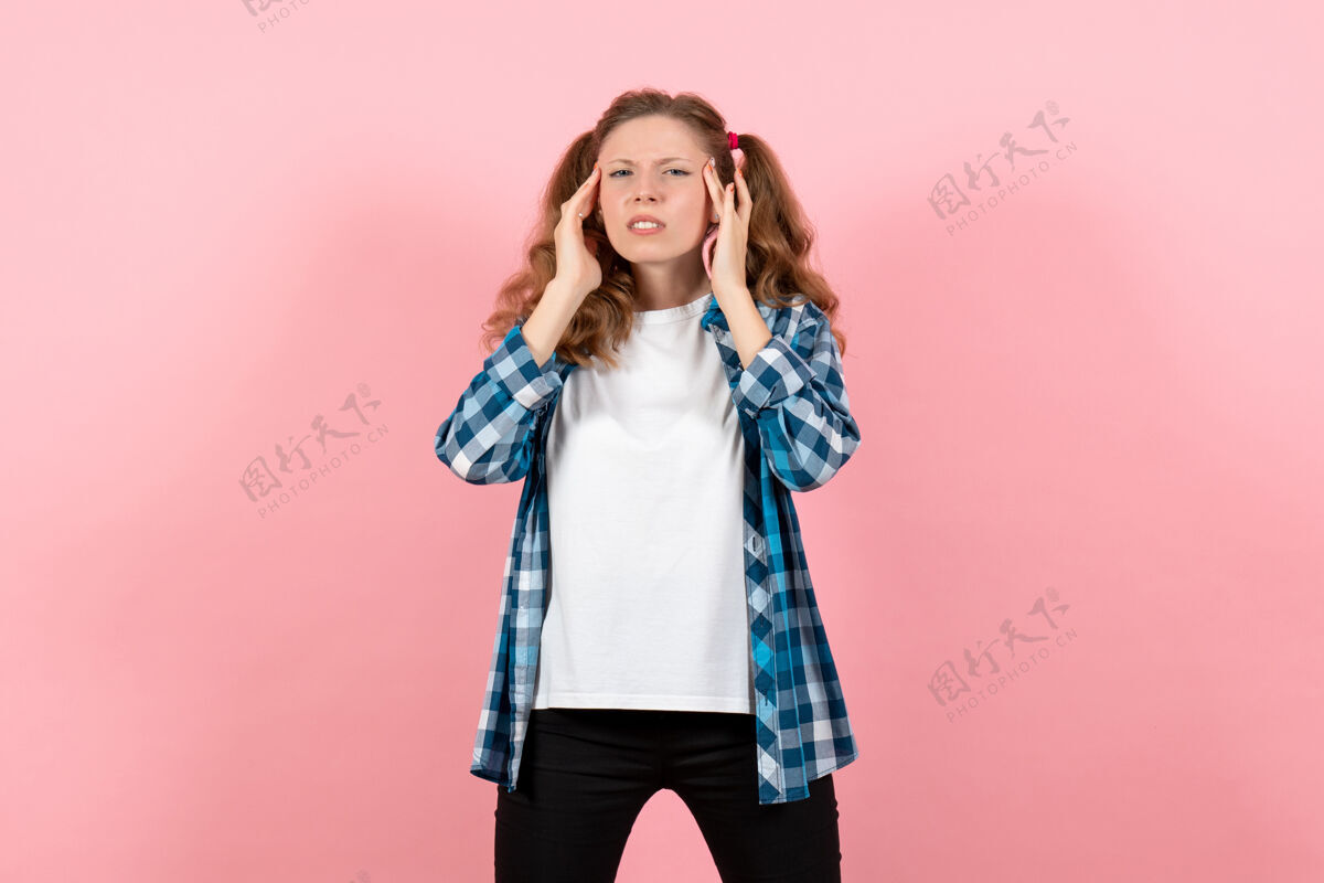 头发正面图：穿着格子衬衫的年轻女性在粉色背景上摆姿势 女性儿童青少年色彩情感模型微笑肖像姿势