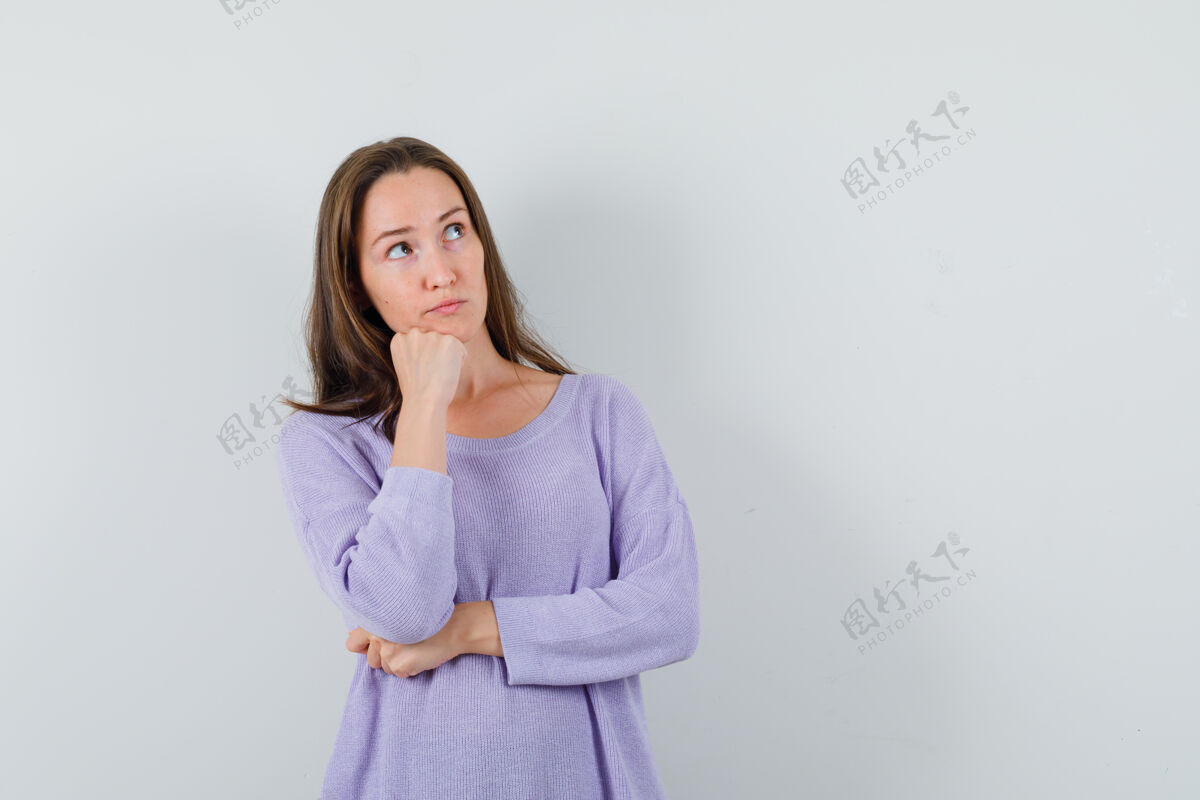 旁白年轻的女性穿着淡紫色的衬衫向旁边望去 看上去很体贴前视图卷发姿势衬衫
