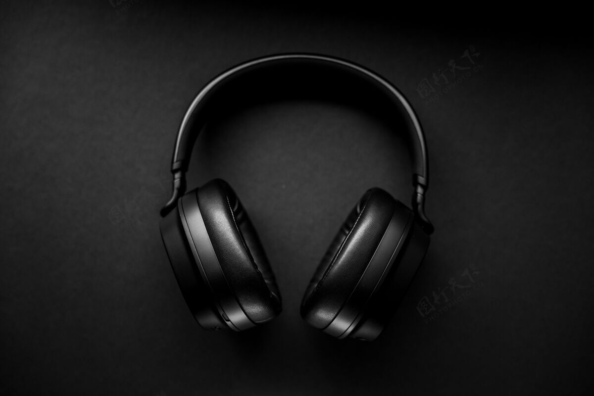 桌子黑色表面的黑色无线耳机耳机耳机音乐