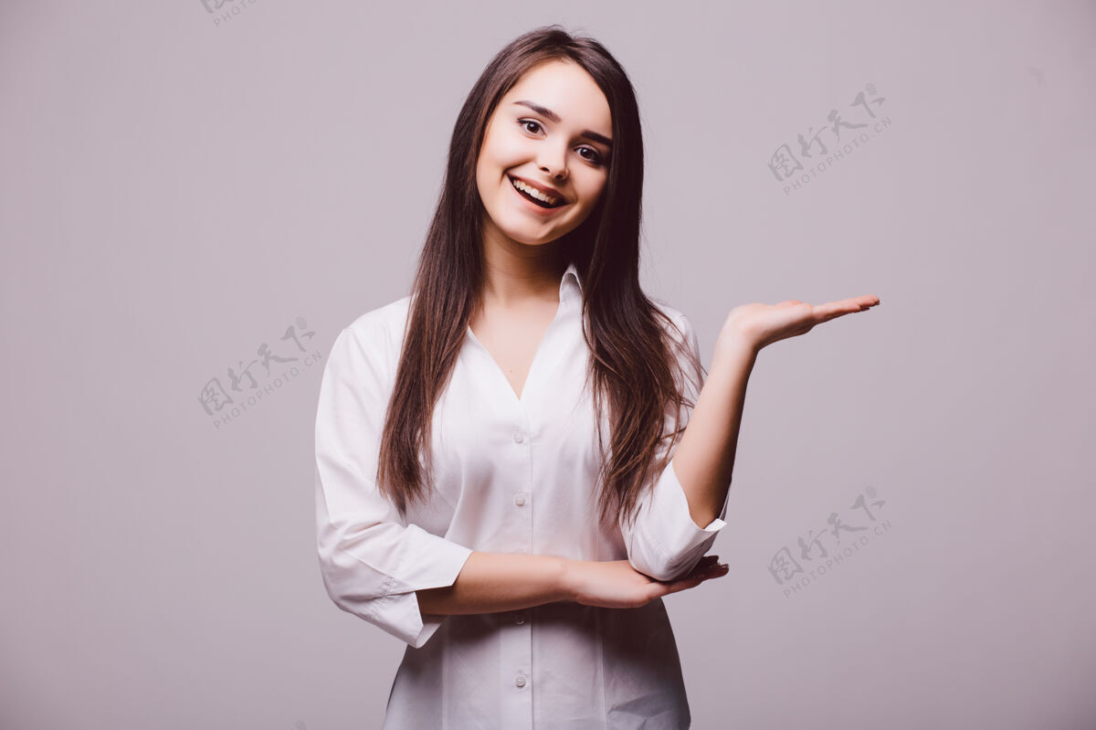 年轻一个女人在她张开的手掌上拿着空白的复印件 站得笔直 孤立地站在白色的背景上女人休闲完整