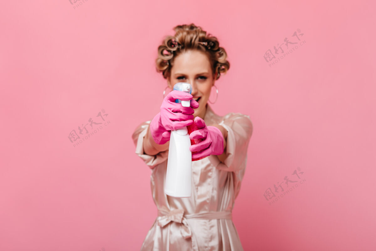 沟通穿着粉色长袍 戴着手套的女人把镜子清洁工引向前面手套浴袍美丽
