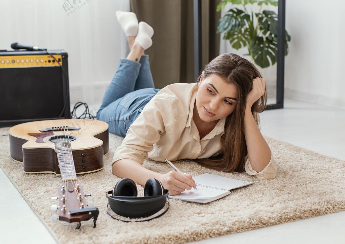 原声吉他女音乐家在家用耳机和原声吉他写歌房子表演音乐