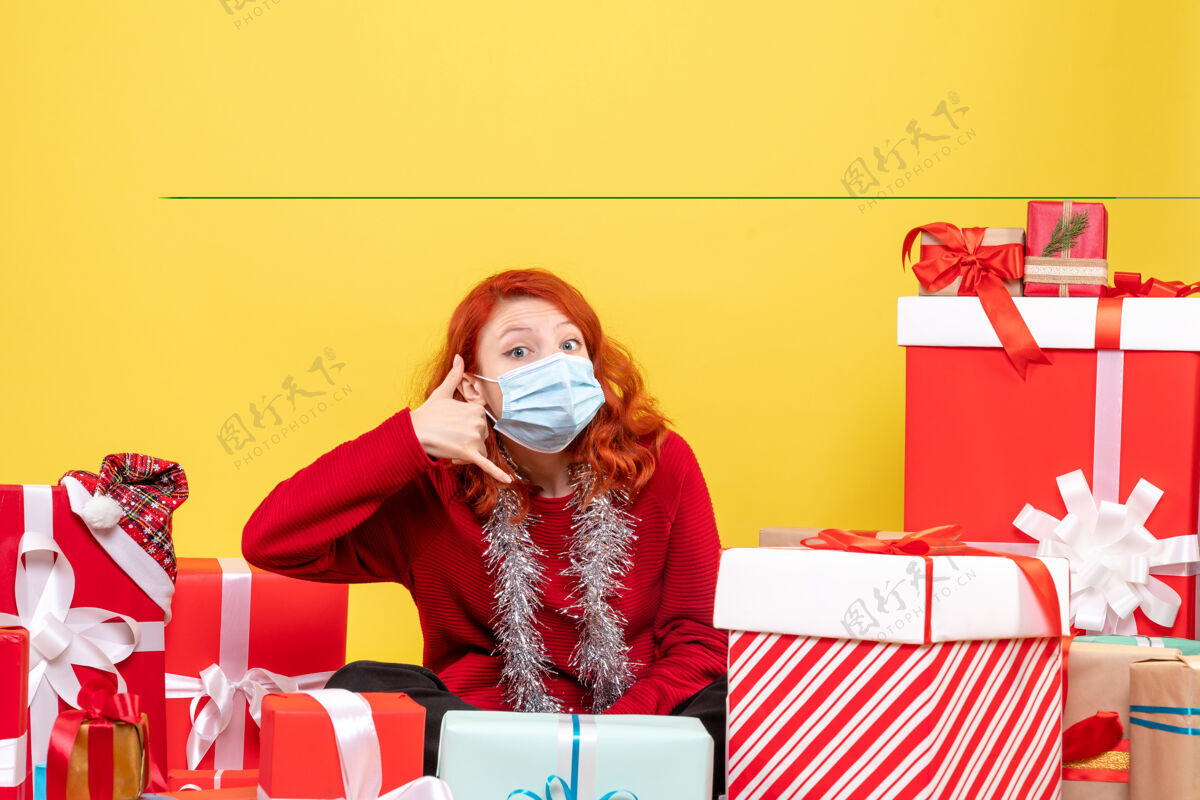 口罩正面图年轻女子围坐在圣诞礼物上 戴着黄色新年情绪的口罩-彩色病毒电脑彩色前面