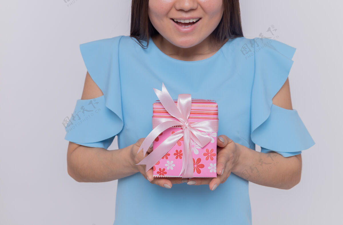 快乐快乐的亚洲蓝衣女子手持礼物站在白墙上庆祝国际妇女节服饰国际亚洲
