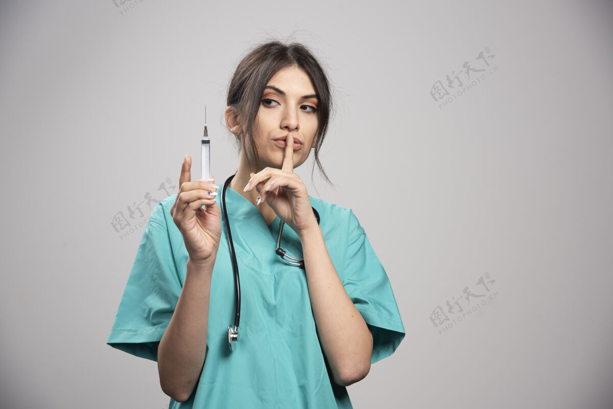 成人女医生拿着注射器在格雷身上工作妇女健康