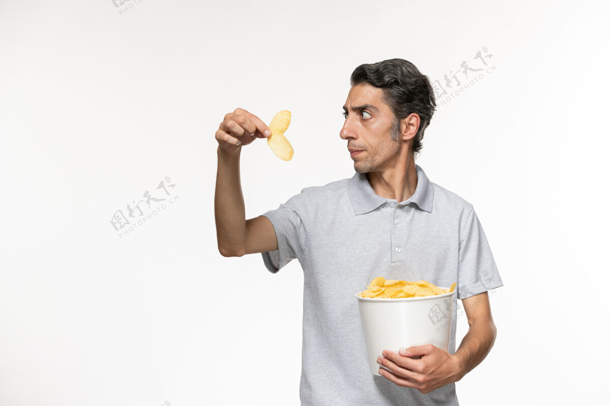 电影正面图：年轻男性手提篮 白色表面上放着薯片男电影篮子