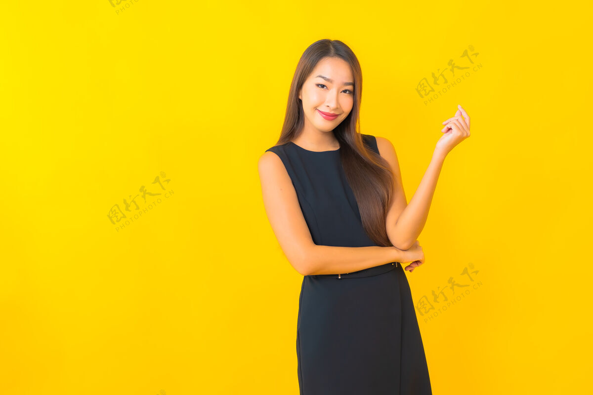 新鲜肖像美丽的年轻亚洲女商人微笑与行动的黄色背景年轻微笑女士