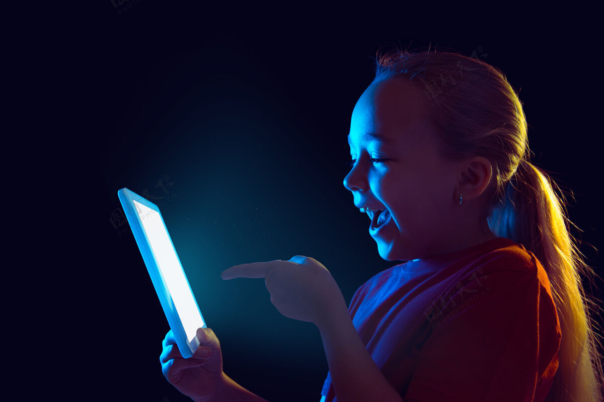 专业霓虹灯下拿着平板电脑的小女孩表达人情感