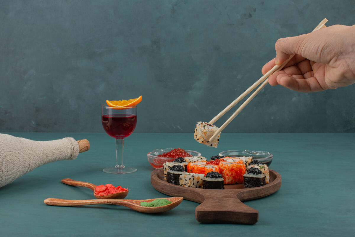酒女人用筷子和一杯酒手拿寿司手酱油食物