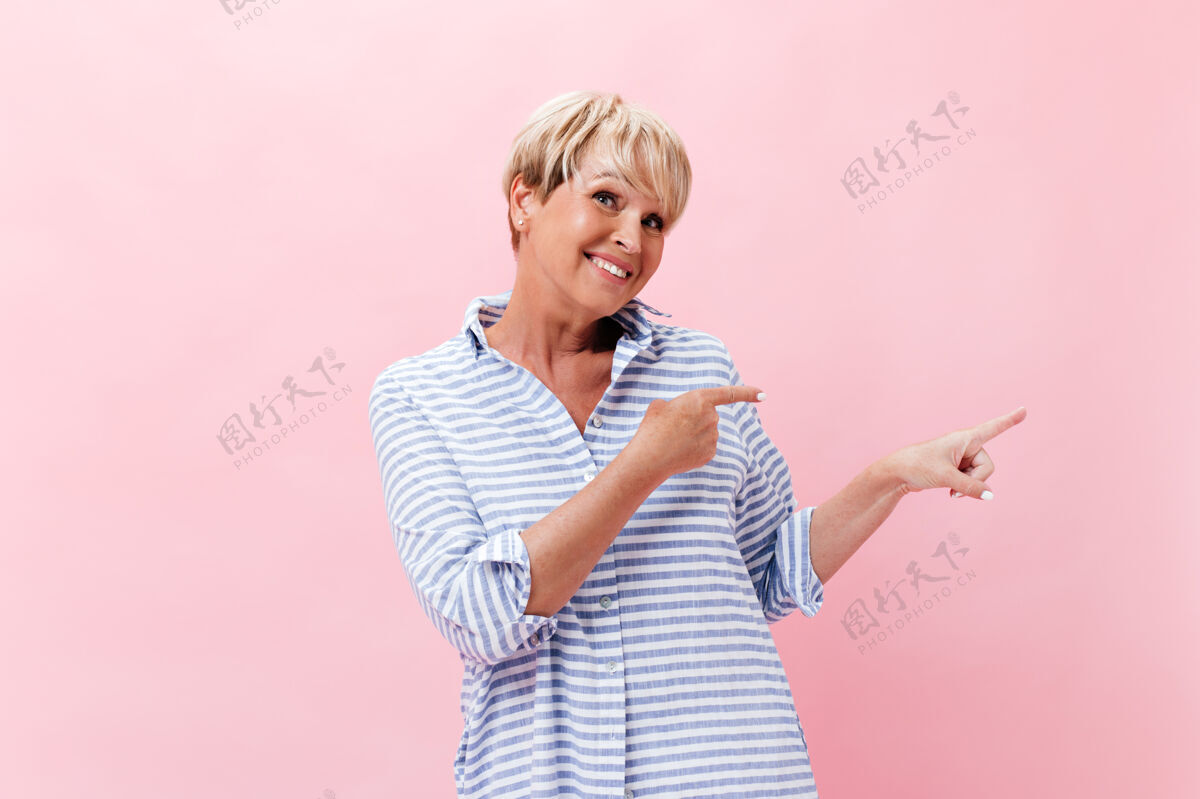 50多岁迷人的女士在格子装点放在粉红色背景上的文字休闲老年成人
