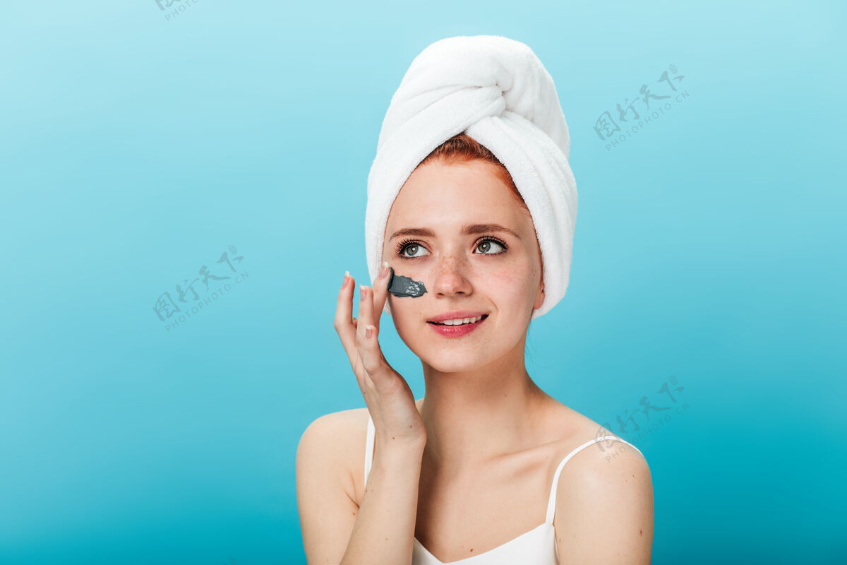 护理幽默的女人在敷面膜开朗的女孩头上戴着毛巾做spa治疗的摄影棚镜头面部女孩美容