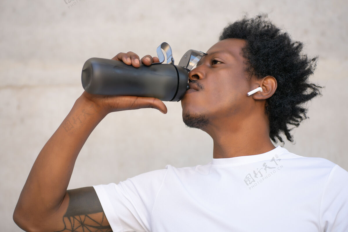 新鲜非裔运动男 户外运动后喝水放松运动和健康的生活方式理念水自信年轻