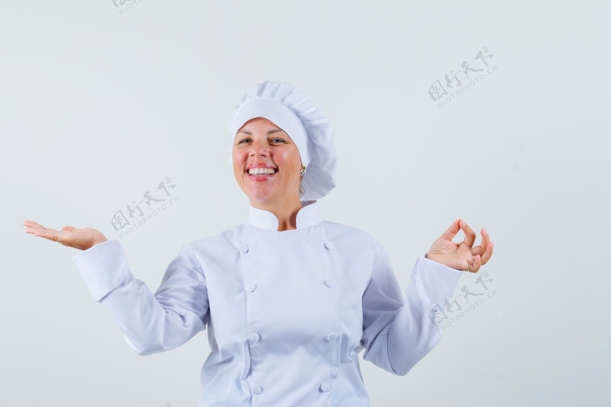 魅力一位身穿白色制服的女厨师 一边摊开手掌 一边摆出ok的姿势 看上去很乐观制服年轻粉色