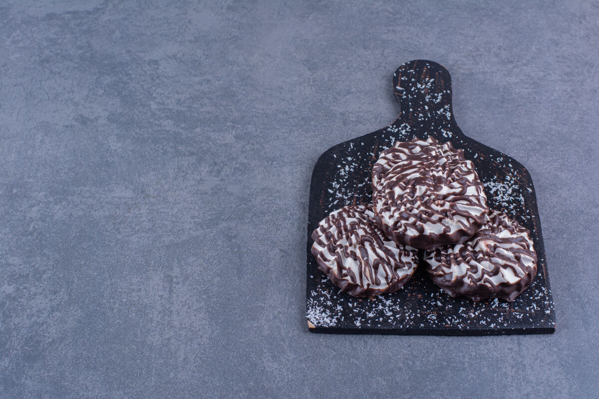 棕色一块黑木板 上面放着巧克力糖浆食物蛋糕液体
