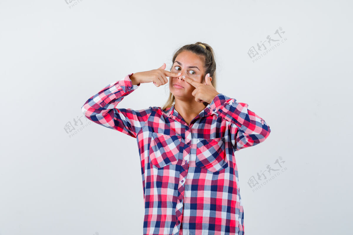 年轻穿着格子衬衫的年轻女士手指贴在鼻子上 神情沉思前视图自然女性成人