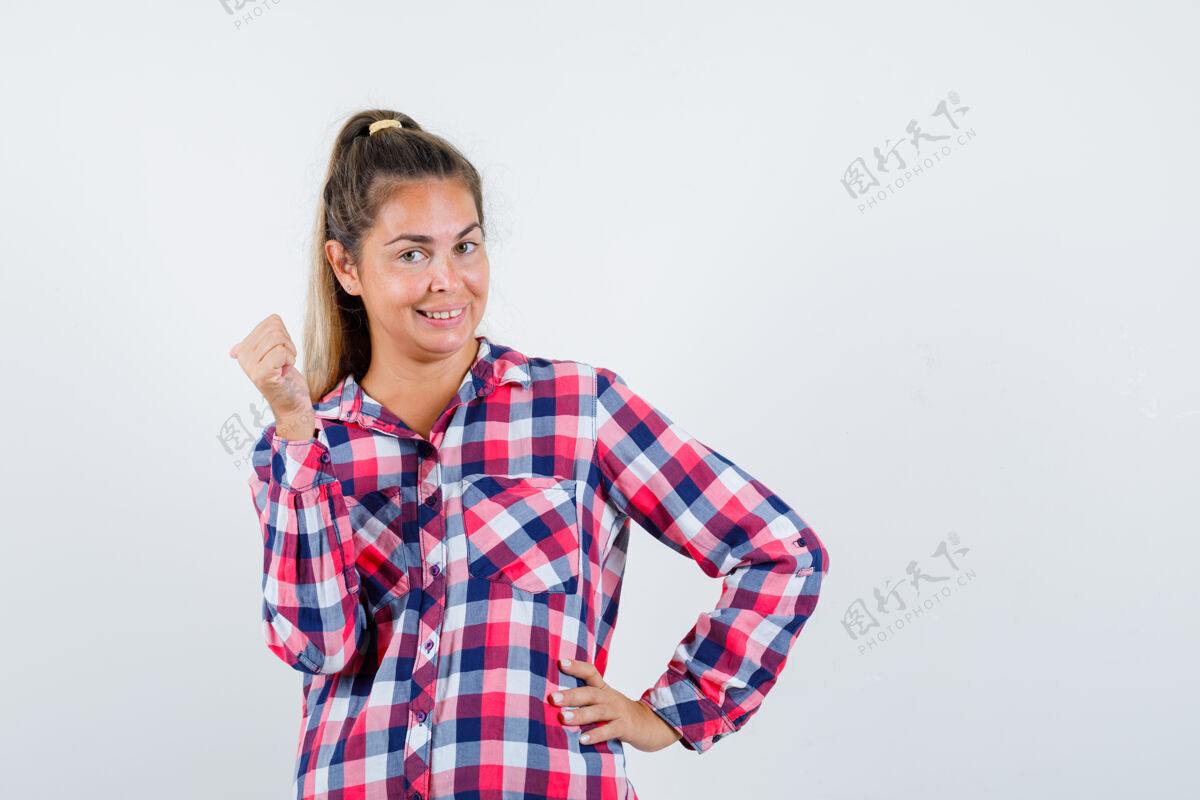 女性穿着格子衬衫的年轻女士用拇指指了指后面 看上去很高兴正视图女士年轻成人