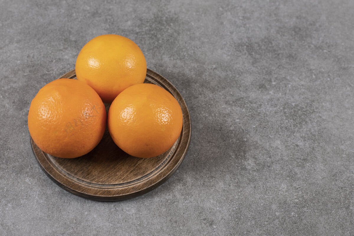 食物灰色桌子上方木板上熟透的橙子的特写照片部分柑橘黄色