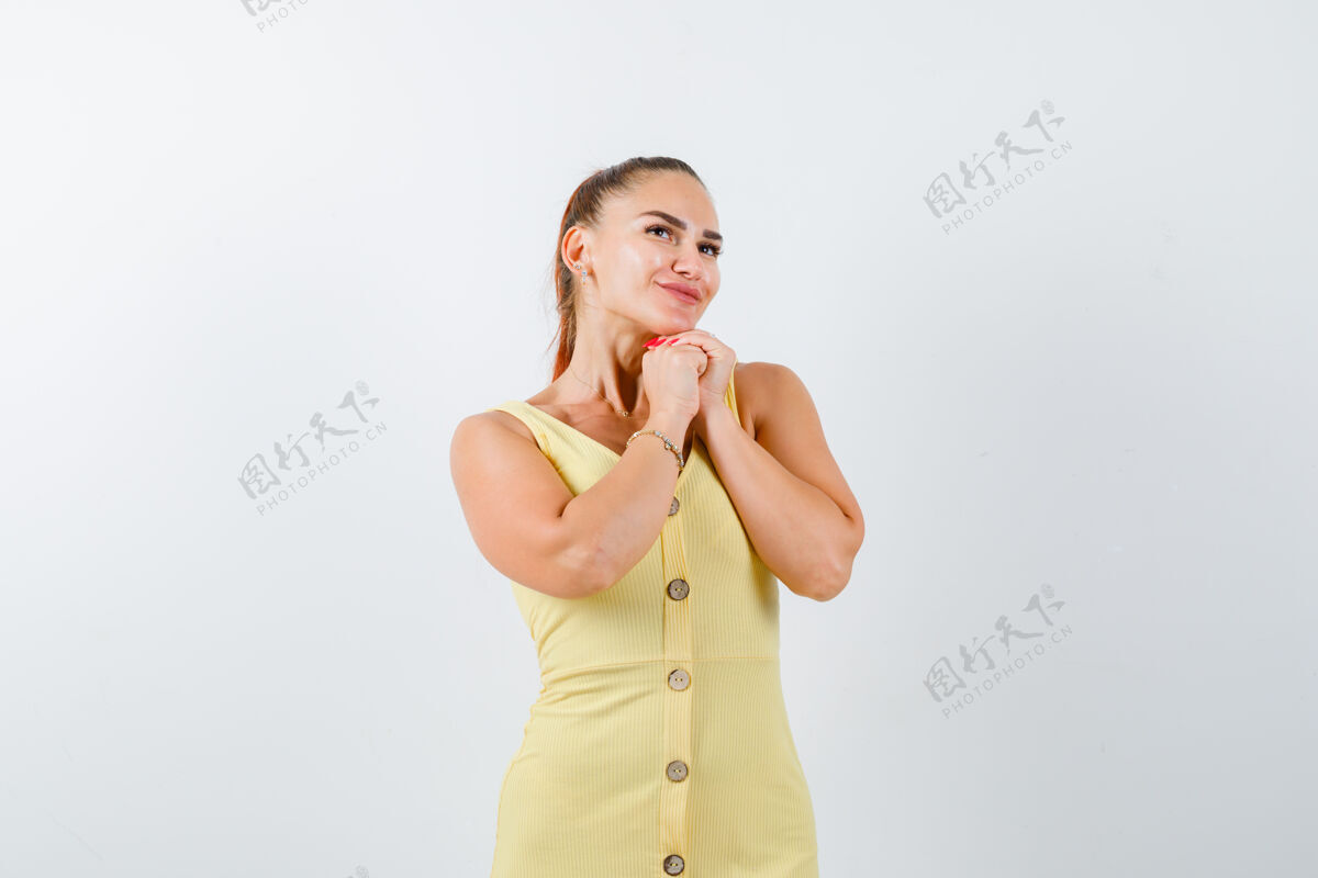女士一幅年轻女子双手合十祈祷的画像 身着黄色礼服抬头仰望平静和平前面睡衣
