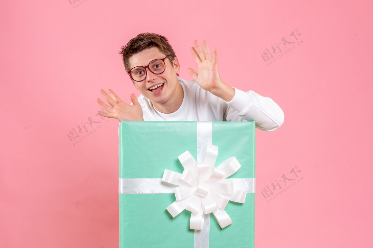 丝带正面图：穿着白色衬衫的年轻男性 粉色背景的礼物微笑白色正面