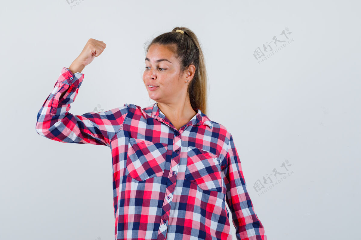 显示年轻女子穿着休闲衬衫展示手臂肌肉的肖像 看起来很自信手臂肖像人