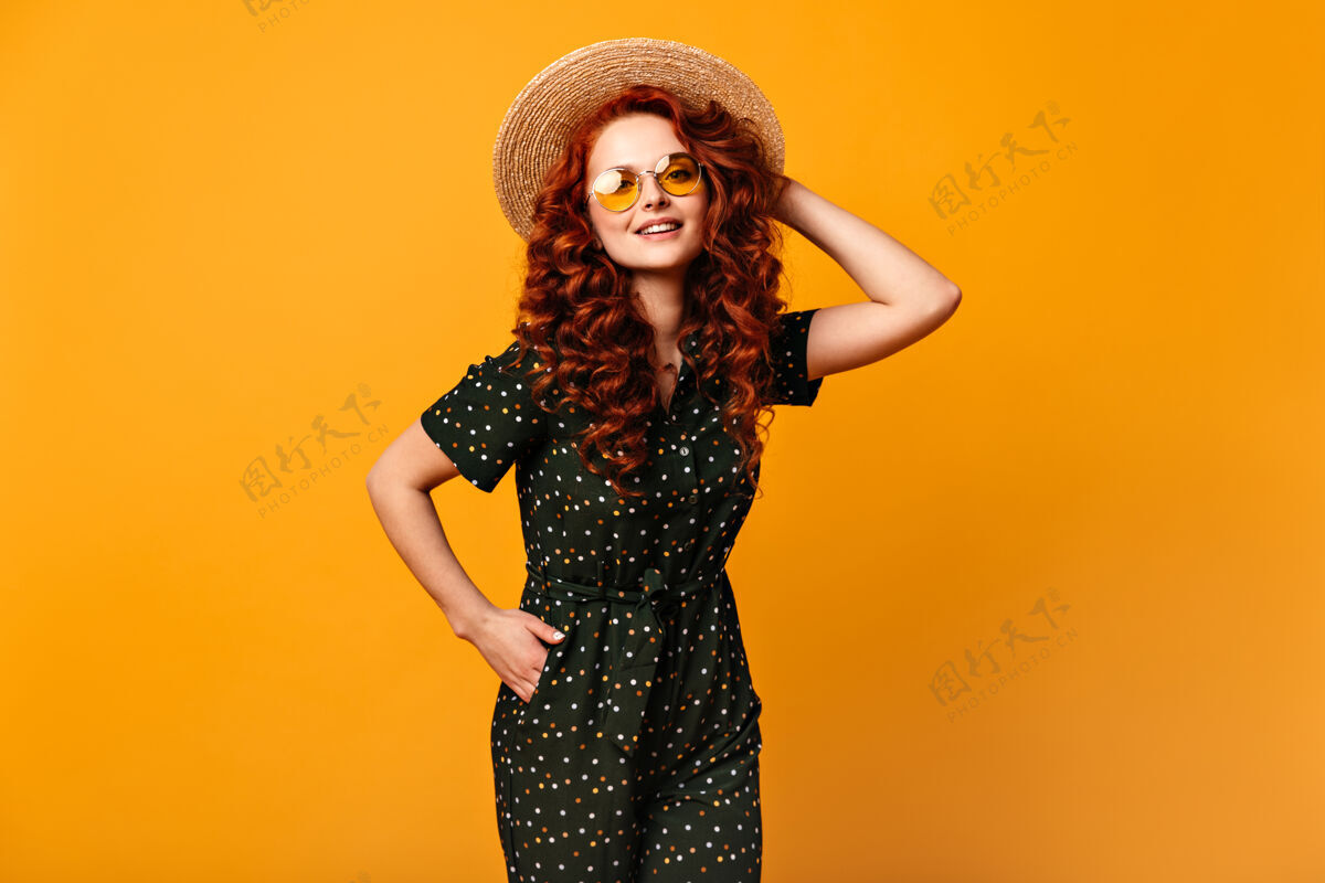 太阳镜灵感女孩戴草帽 手放在口袋里摄影棚拍摄的黄色背景上戴着墨镜的快乐微笑的姜女表情欢呼姜黄色