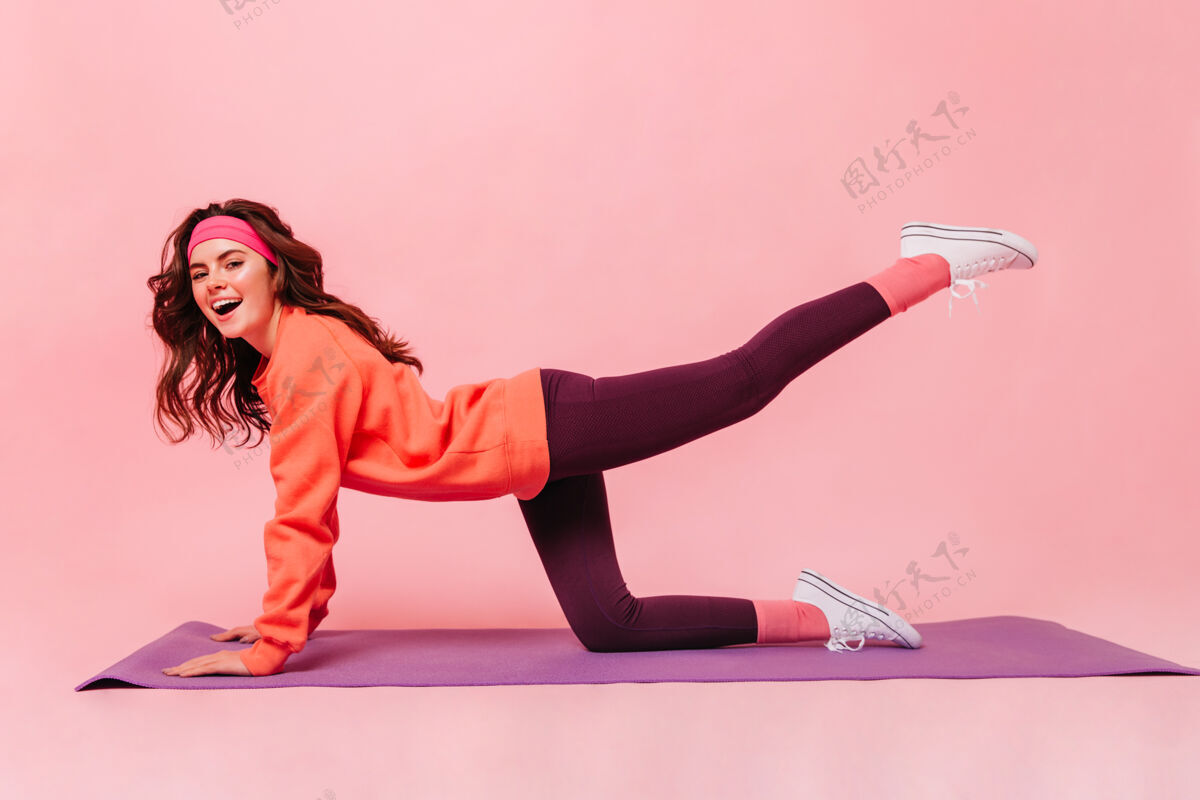 运动员活跃的女士在紫色健身垫上锻炼腿部身体运动服运动