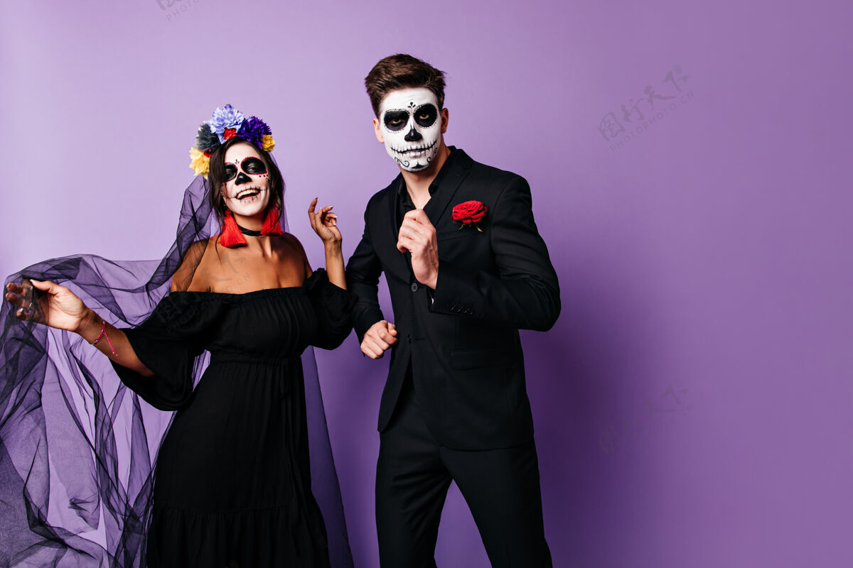 化妆活泼的男人和他穿黑色衣服的女人在万圣节派对上玩得很开心跳舞嘉年华节日西班牙