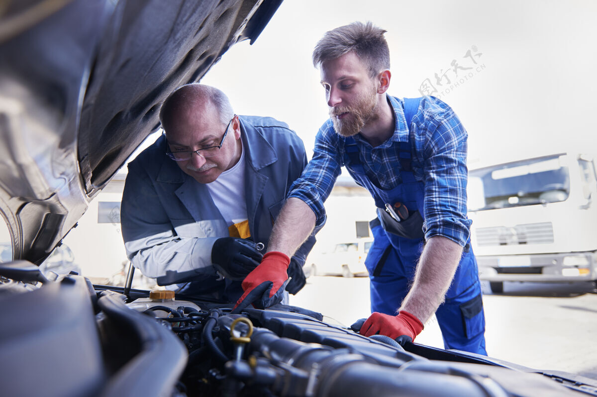 工作修理工在车间里修理汽车业务汽车技工防护手套