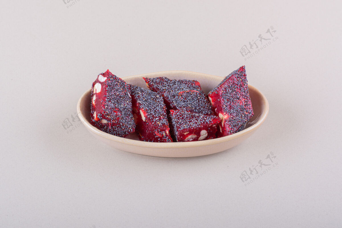 坚果甜甜的红色糖果和坚果在米色碗白色表面高品质的照片零食糖果好吃的