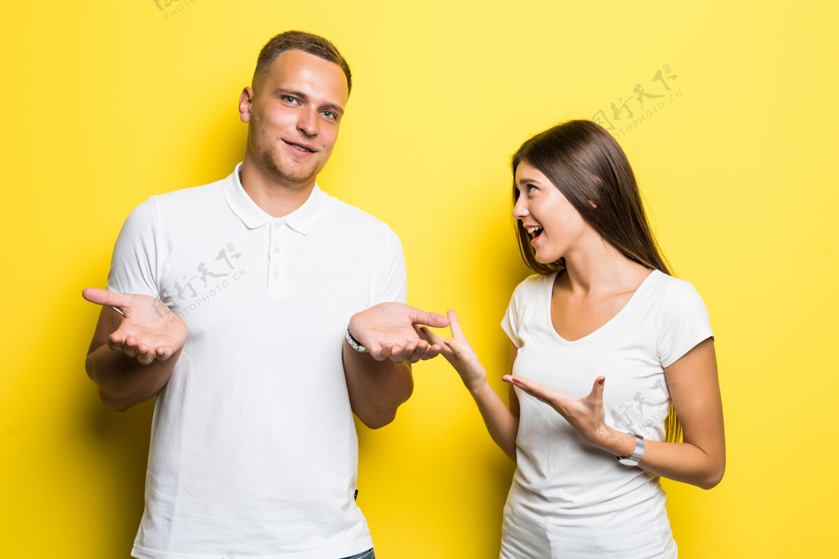 女性一对被隔离在黄色背景下的年轻夫妇穿着白色t恤一起交谈成人脸年轻