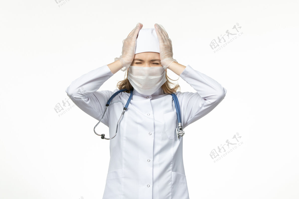 到期正面图女医生穿着医疗服戴口罩和手套因冠状病毒轻壁病病毒冠状病毒-大流行性疾病人医学光