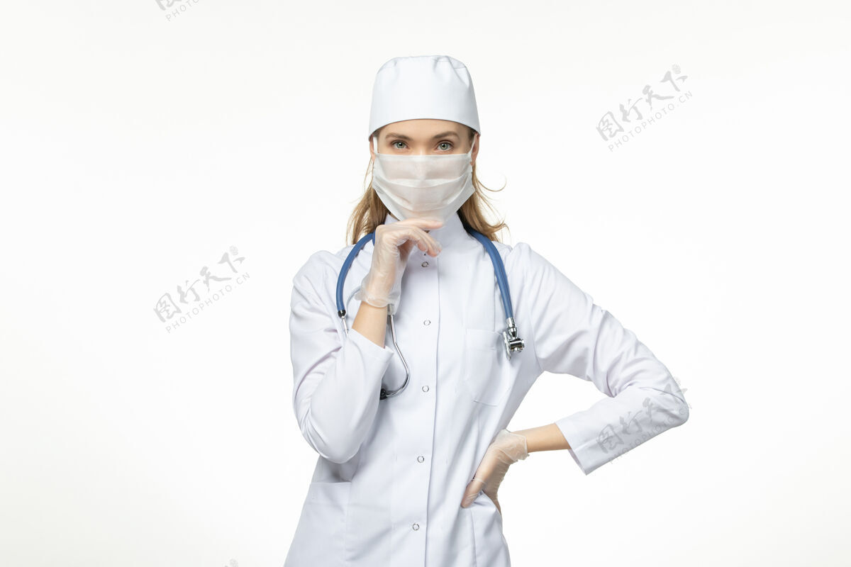 面罩因冠状病毒而戴口罩和手套的女医生正穿着医疗服 思考白色书桌病病毒冠状病毒-大流行性疾病正面到期冠状病毒