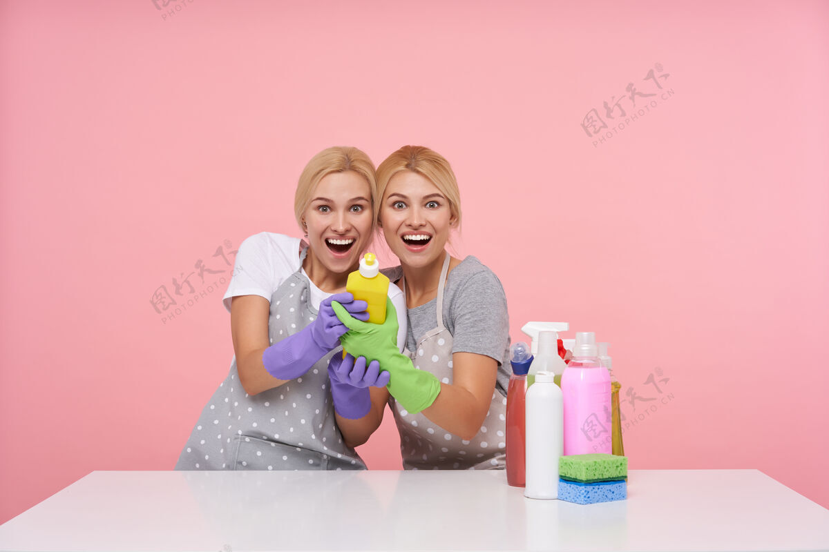 洗涤剂年轻的金发可爱的主妇们戴着橡胶手套准备春季大扫除金发妹妹家庭