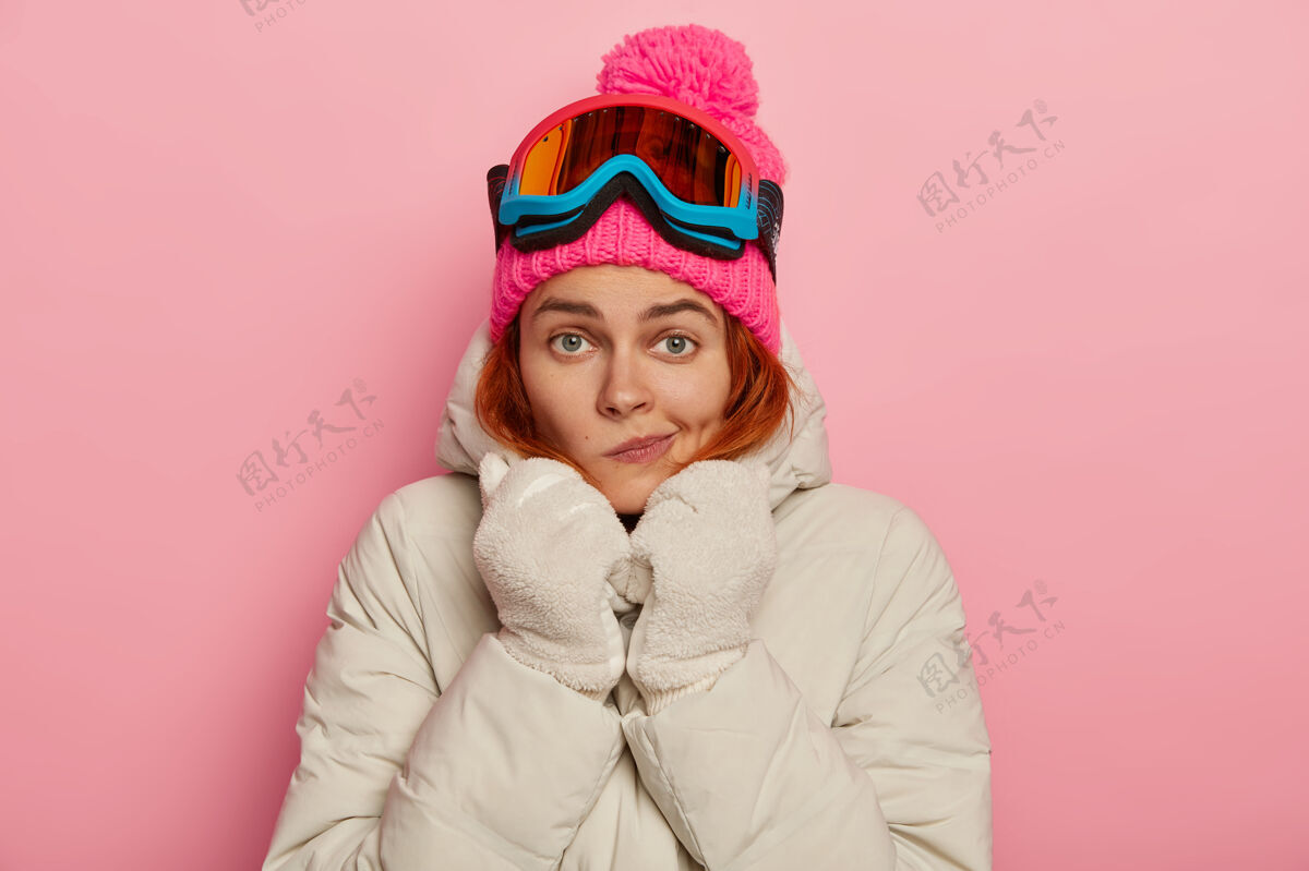眼镜可爱的女旅行者的照片 在冬天的时候把嘴唇包起来 穿着舒适的外套取暖 戴着滑雪面具滑雪板冬季白种人