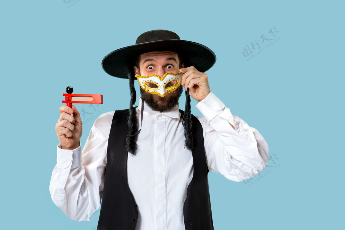 犹太人一个年轻的东正教犹太男子与木制棘轮在普瑞姆节画像面具神圣犹太教